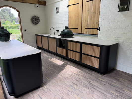 Buitenkeuken met kookgedeelte en baropstelling met uitzicht op de tuin
